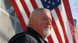 man staring with american flag in the background