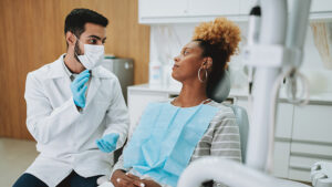Dentist and patient visiting during an appointment.