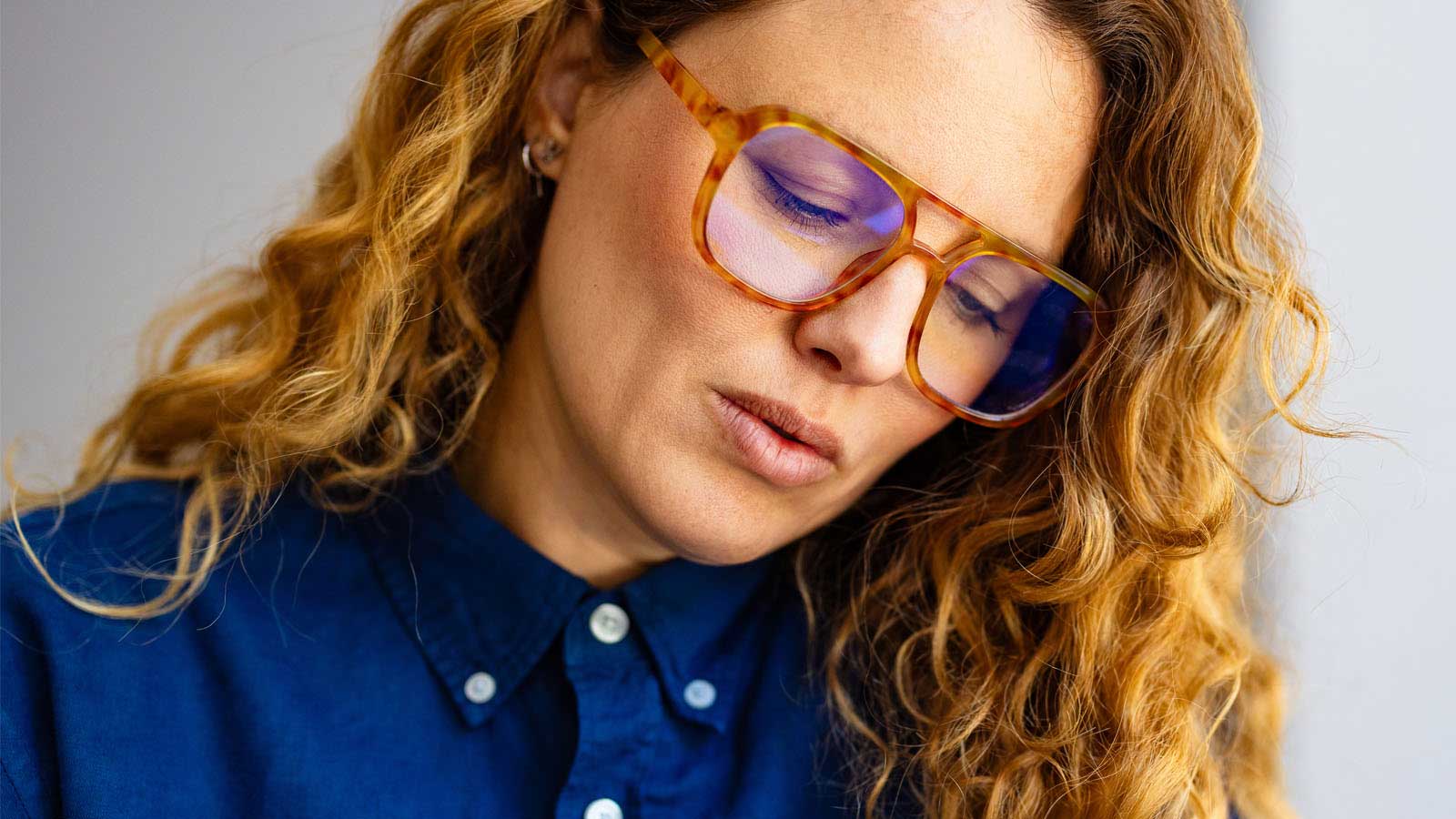 Close-up of female looking down, wearing glasses.