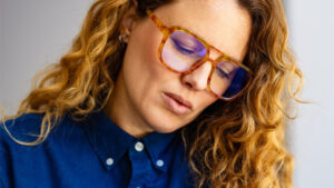 Close-up of female looking down, wearing glasses.