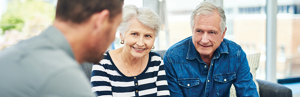Elderly couple talking with a financial advisor.