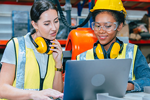 Women engineer worker working team training together at work in modern advanced robot welding machine factory.