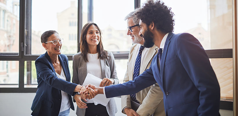 Small group of business professionals shaking hands.