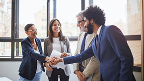 Small group of business professionals shaking hands.