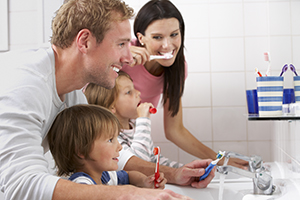 Family In Bathroom Brushing Teeth
