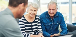 An elderly couple having a discussion with their financial advisor.