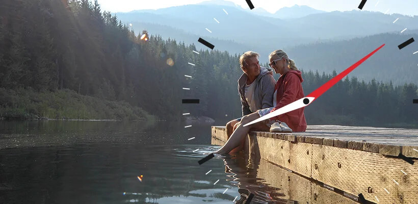 Couple sitting on a dock with their feet in the water.