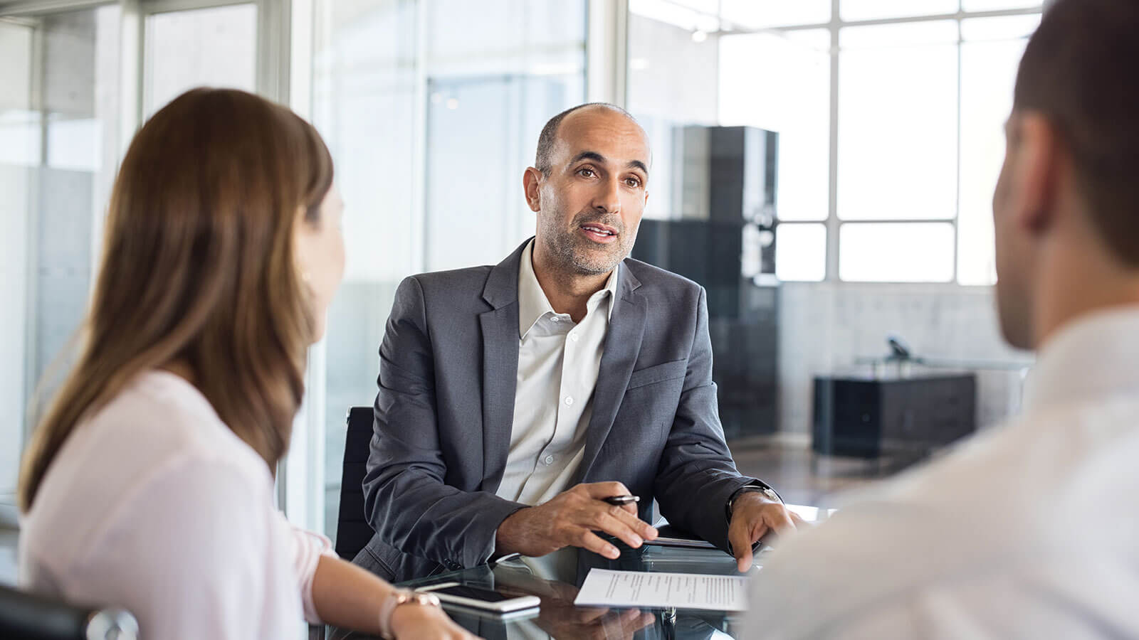 A married couple meets with their financial professional to learn about the differences in permanent life insurance versus term life insurance.