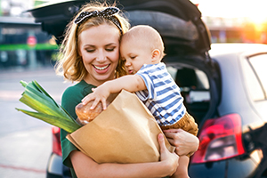 Young mother with baby boy in front of a supermarket.