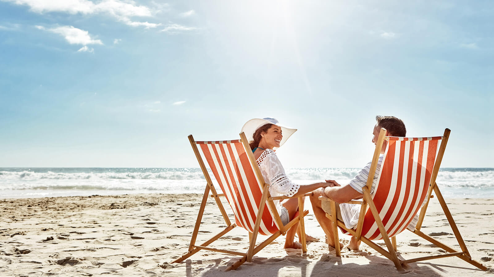 A husband and wife enjoy their retirement together on a beach because they planned well with an annuity indexing strategy.