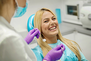 Female dentist and young woman patient in dentist office.