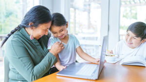 A mom laughs with her young son and daughter at the breakfast table. If anything happened to her, she has the right amount of life insurance to protect them.