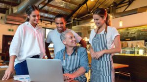Restaurant owner working with employees at a computer