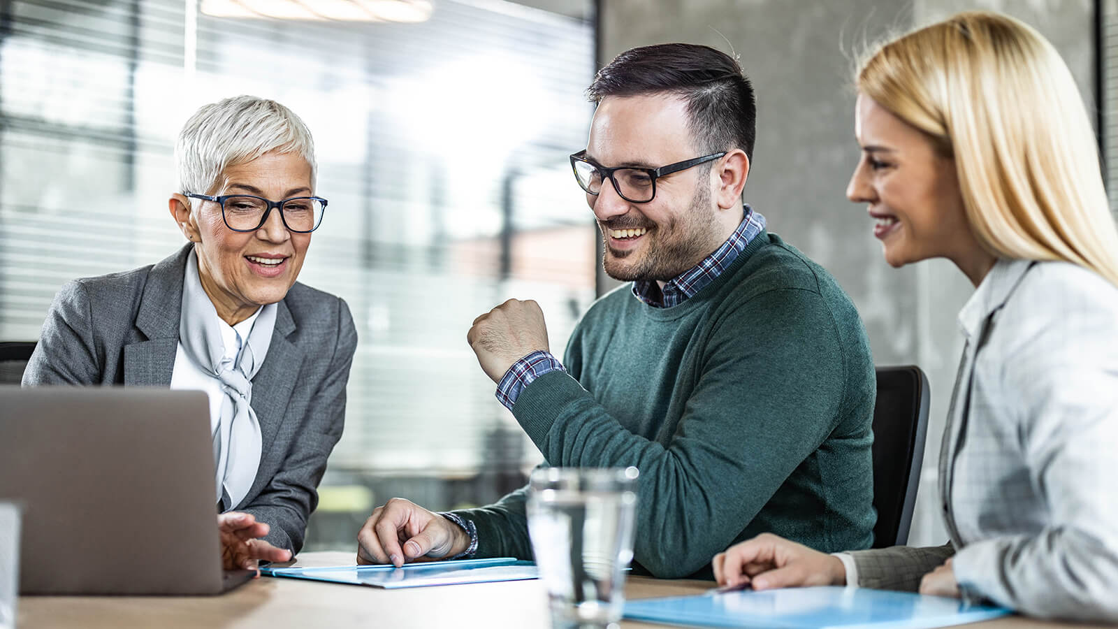  A female financial professional meets with her clients to discuss 401(k) rollover rules and what to do with their abandoned retirement accounts.