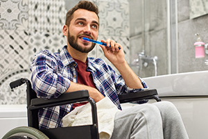 Handicapped man brushing teeth at home bathroom