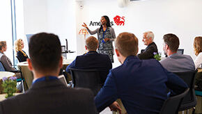 Female leading a meeting of business colleagues in a conference room.