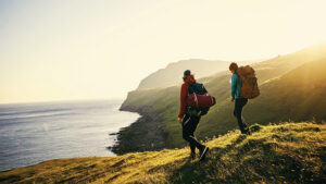 A young couple hiking on a hilly coastline.