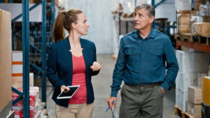 Two businesspeople talking in a warehouse.