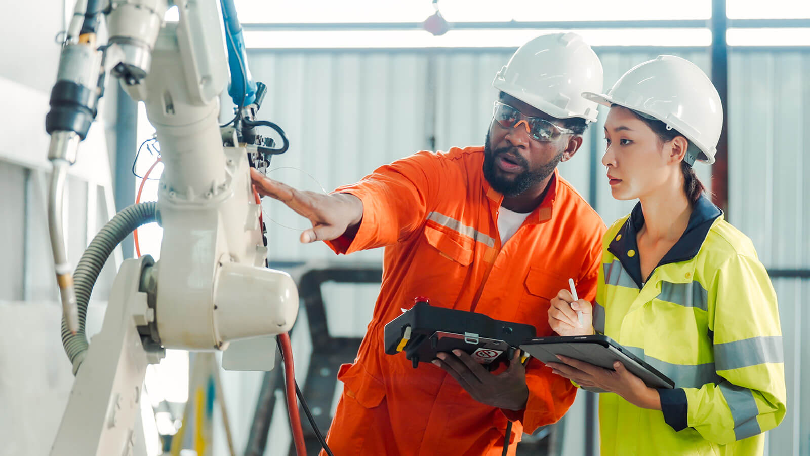 Two workers examine a piece of equipment