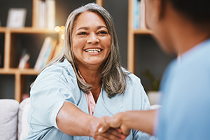 Happy female shaking hands with another individual.