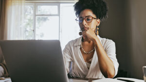 A young woman researches how to start saving for retirement on her laptop.