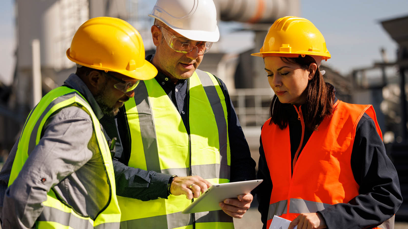 Colleagues wearing hard hats review building design plans for their business. To attract the best employees, they’ll need to consider joining a MEP or PEP to offer a retirement plan.