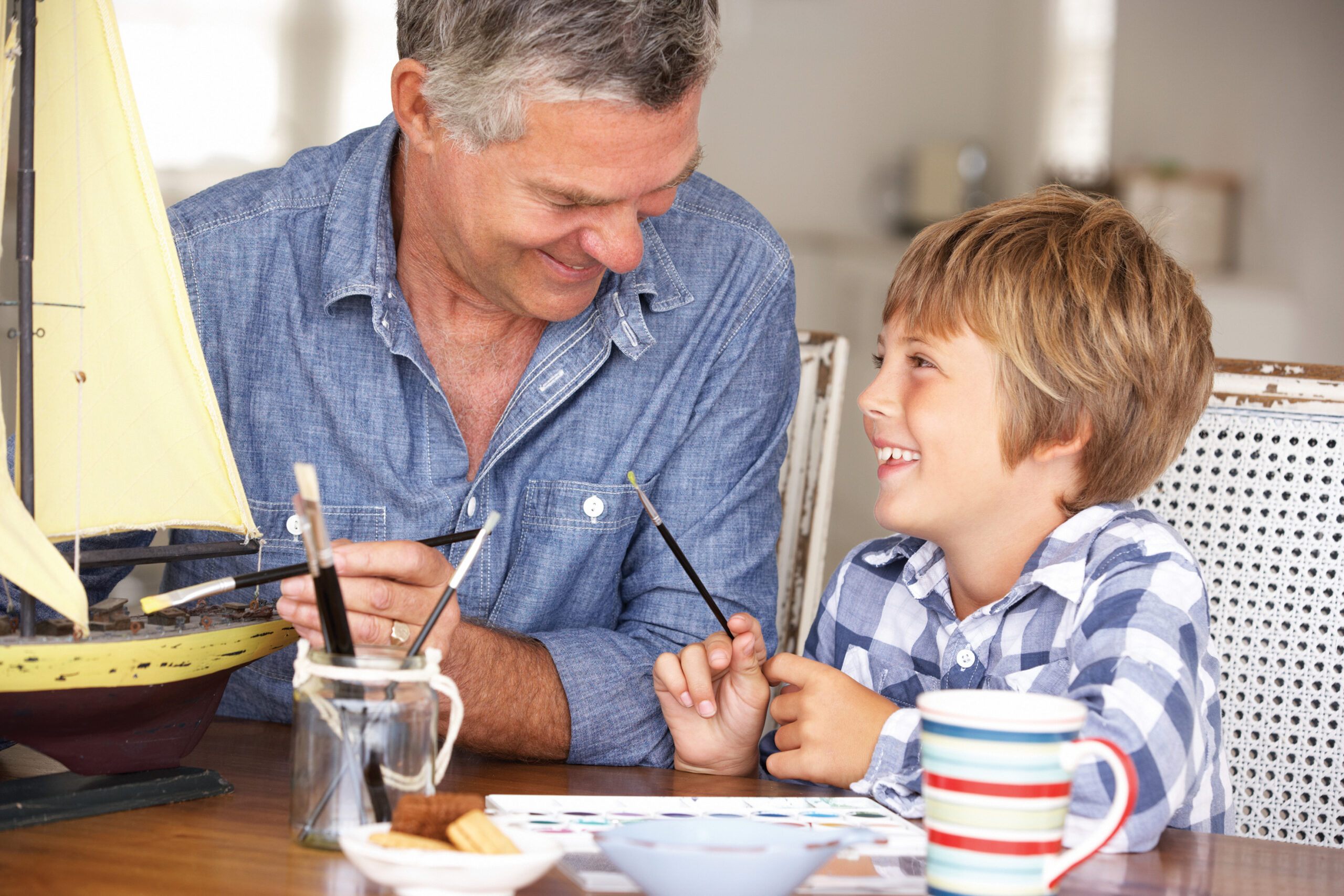 A man builds a model with his grandson