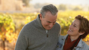 A husband and wife in their 50s take a walk on a beautiful fall day. They’re relaxed knowing they have employer life insurance.