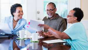 A retired couple meets with their financial professional to discuss the benefits of tax deferral in their financial strategies.