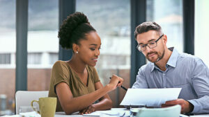 Male and female sitting at a table explaining annual maximum.