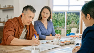A couple meets with their financial professional to learn about while life insurance with dividends.