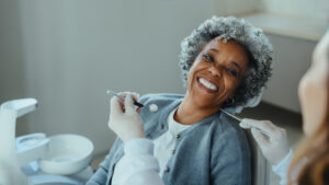 Female patient, smiling, sitting in dental chair.