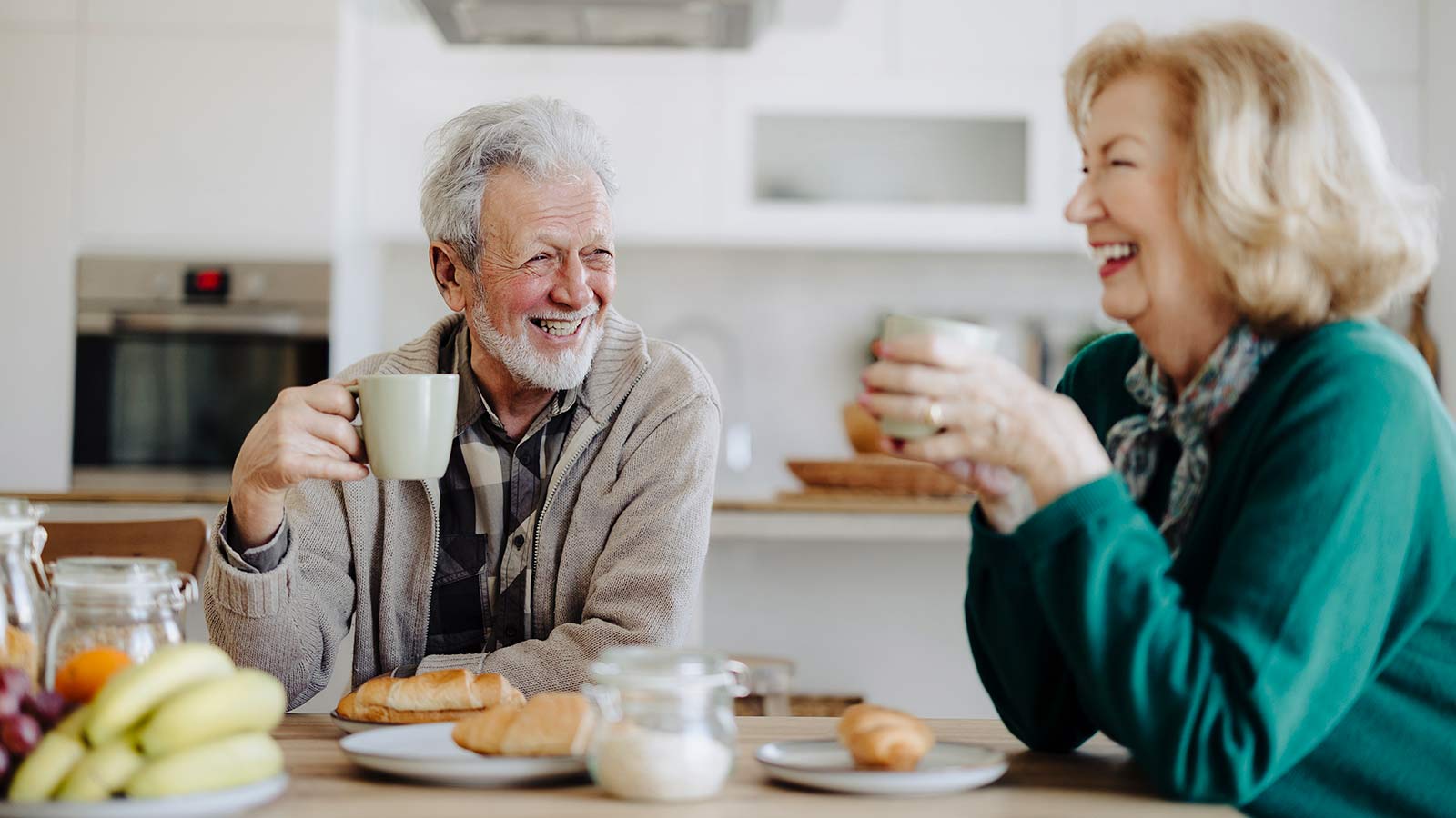 Older couple drinking coffee and smiling at the table. Older couple drinking coffee and smiling at the table.