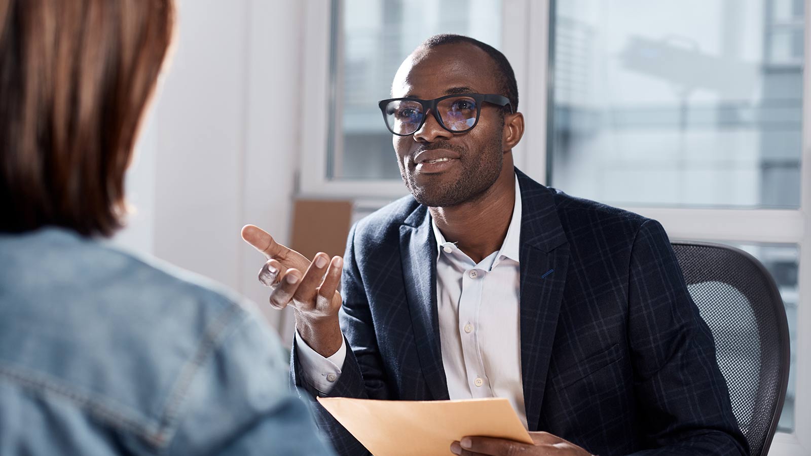 Man sitting at a table, holding papers and explaining himself. Man sitting at a table, holding papers and explaining himself.