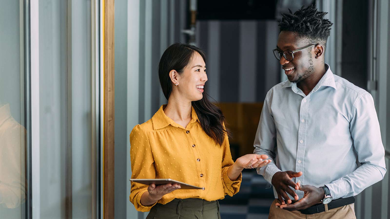 Man in glasses having conversation with woman in yellow shirt. Man in glasses having conversation with woman in yellow shirt.