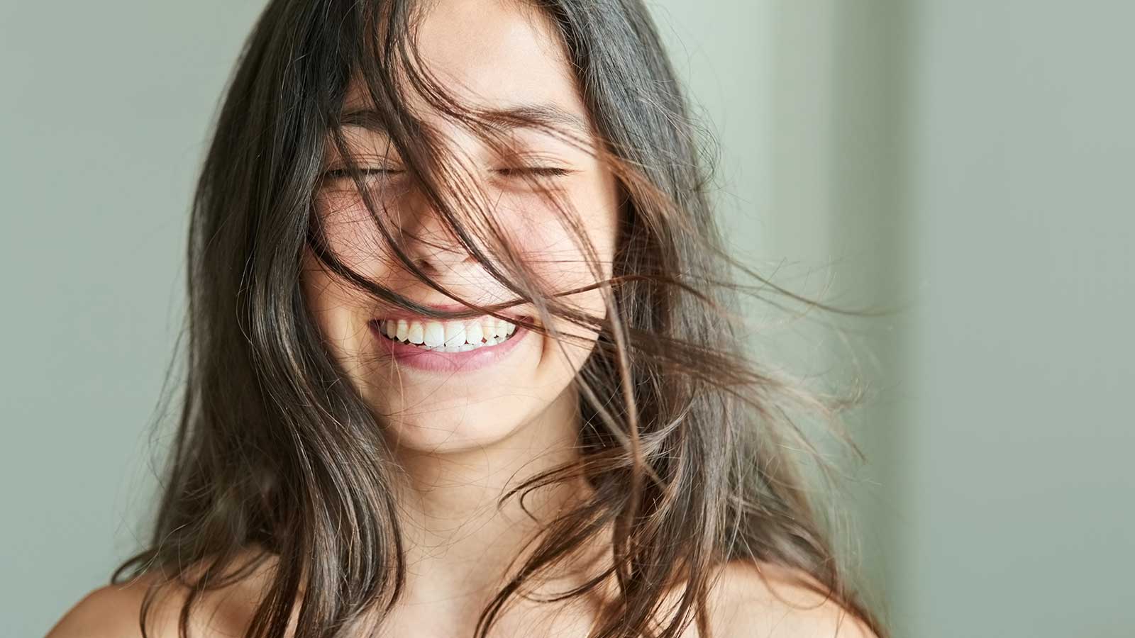 Girl smiling, showing her teeth with hair in her face. Girl smiling, showing her teeth with hair in her face.