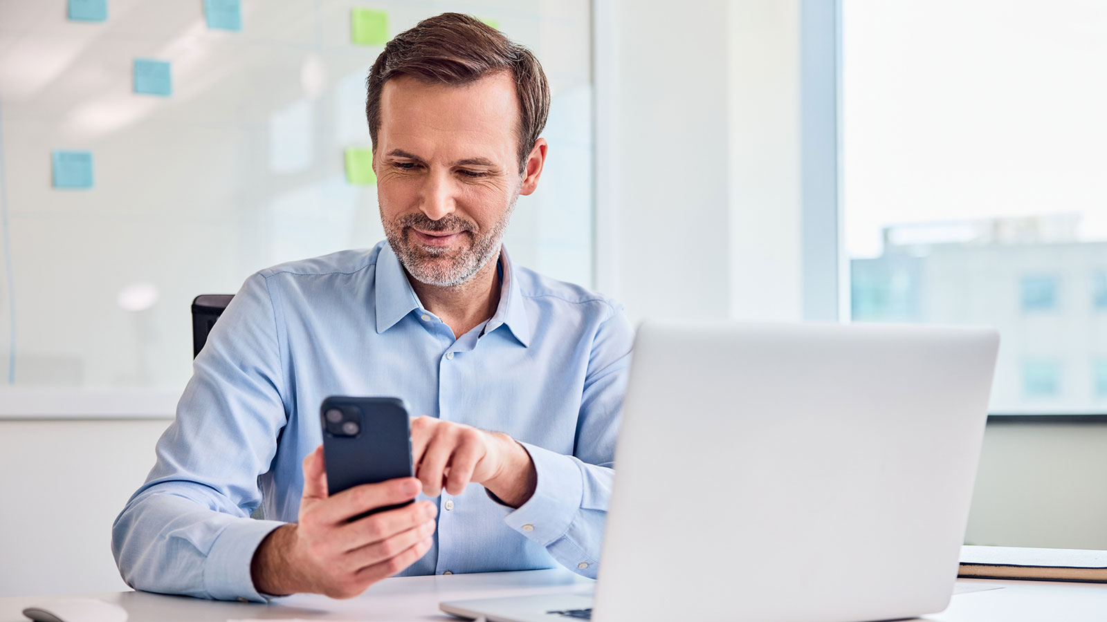 A financial professional sits at his office desk and checks social media best practices on his phone to help grow his business and engage clients. A financial professional sits at his office desk and checks social media best practices on his phone to help grow his business and engage clients.
