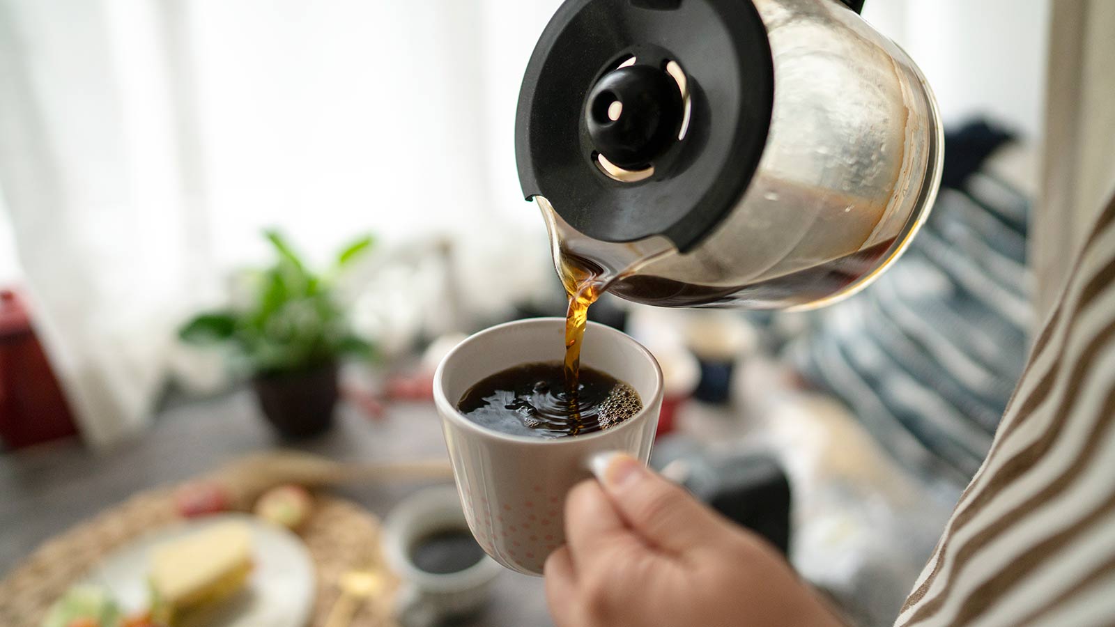 Pouring a cup of coffee.