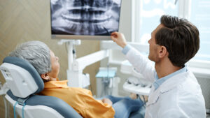 A dentist and patient looking at dental x-rays.