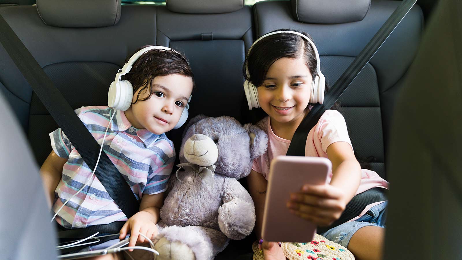 Kids watching a fun video on a road trip