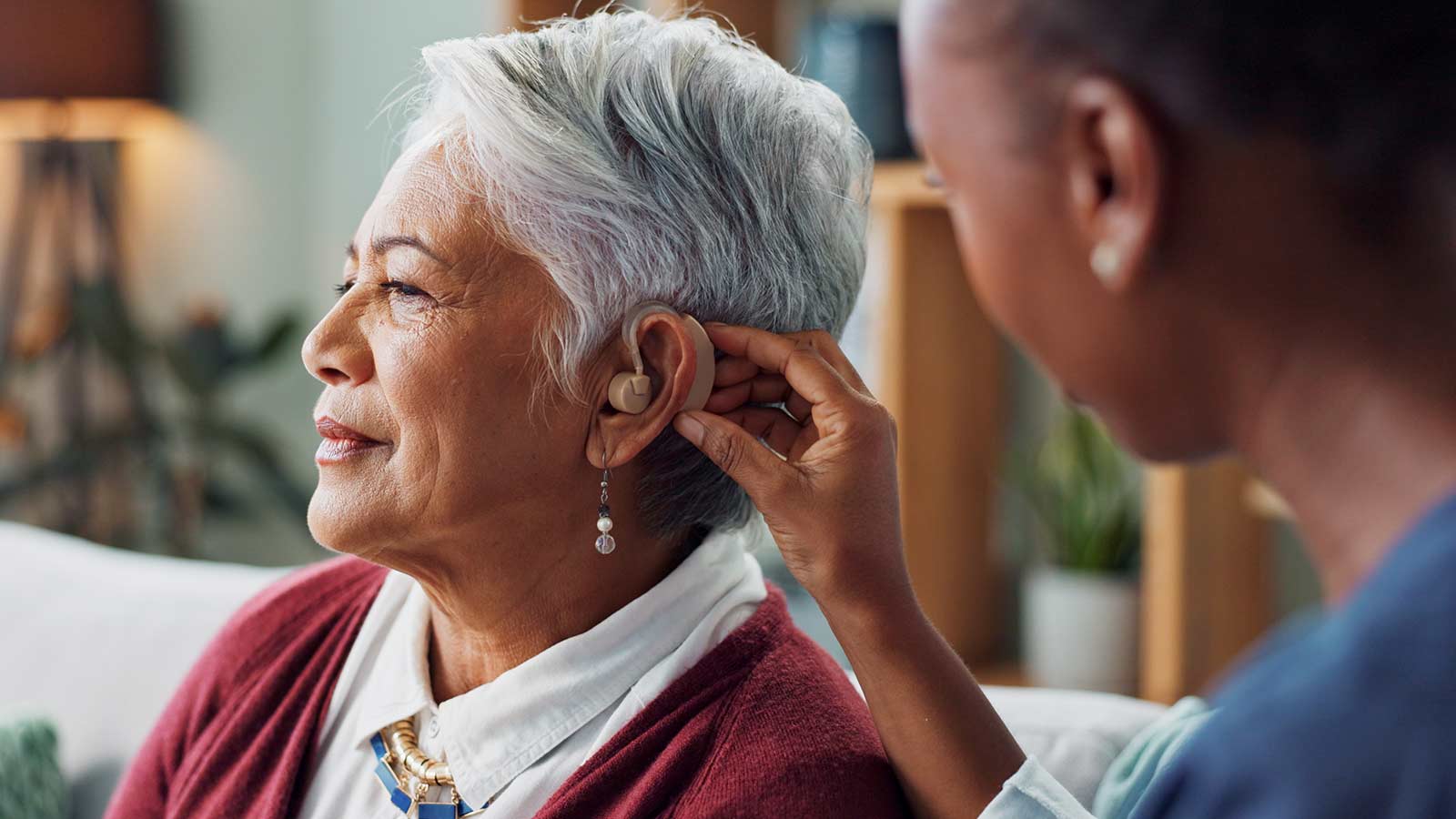 Elderly woman being fitted for hearing aids.