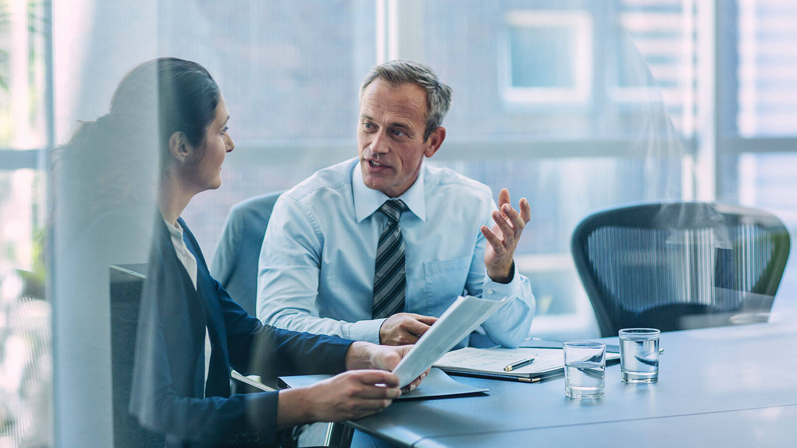 Two business colleagues having a conversation at a table.