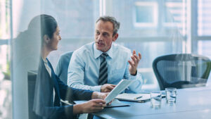 Two business colleagues having a conversation at a table.