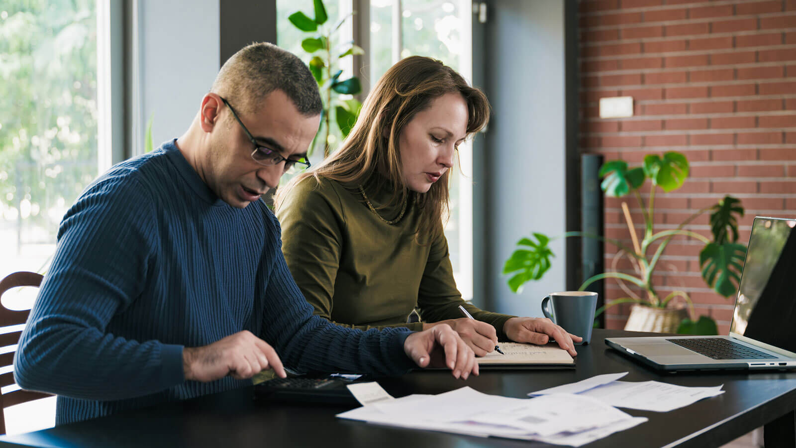 A husband and wife sit together preparing their tax documents so they’re ready for tax season.