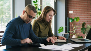 A husband and wife sit together preparing their tax documents so they’re ready for tax season.