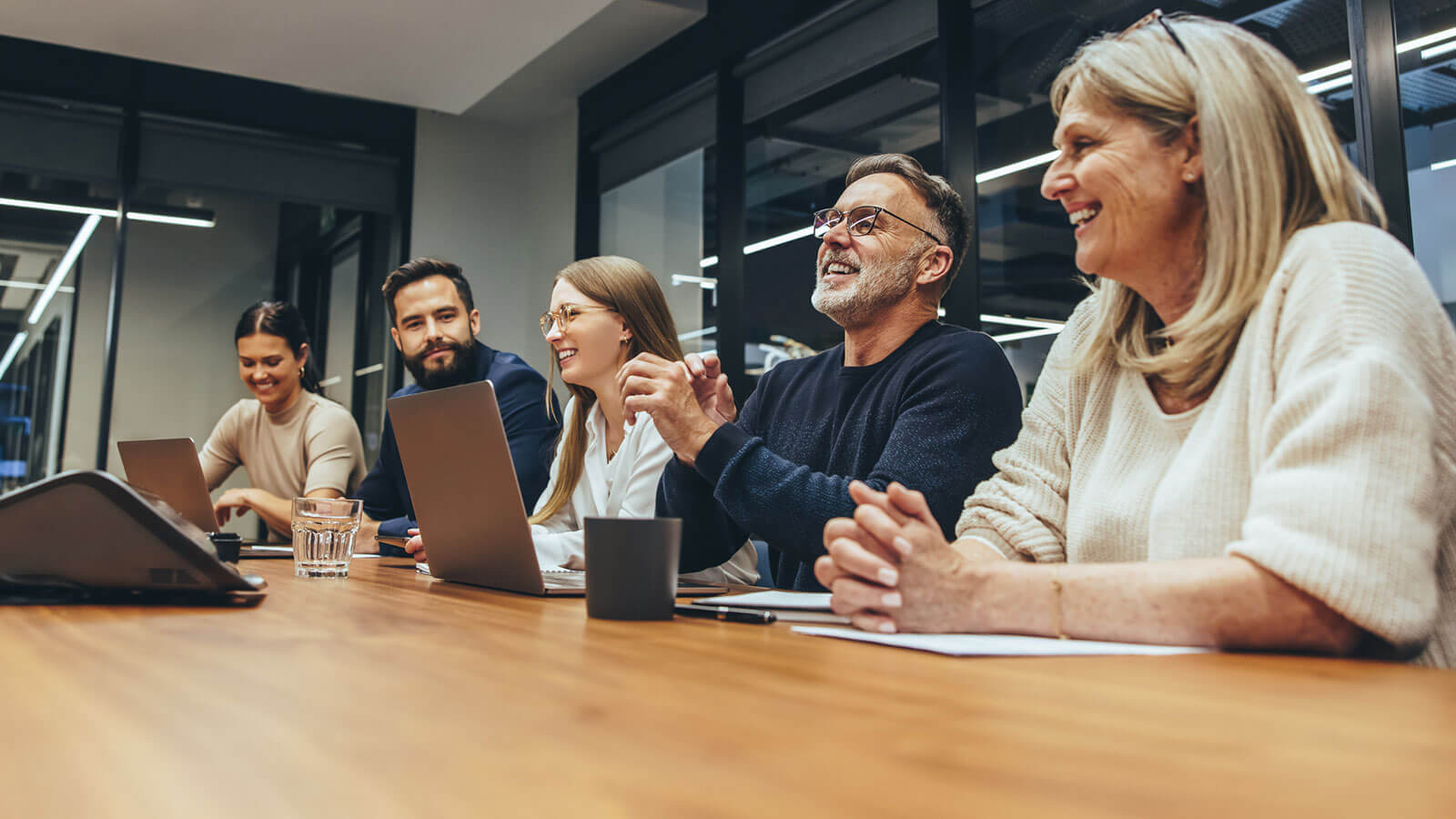 A group of employees are collaborating in a conference room discussing an upcoming project.