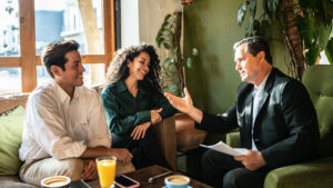 A financial professional explains the benefits of whole life insurance with her client while reviewing the client’s paperwork in a conference room.