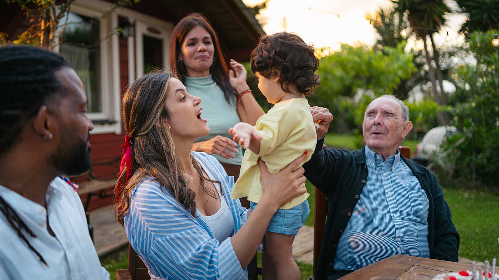 Young mother holding her child and celebrating with family.