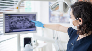 Woman pointing to Dental radiogram on screen
