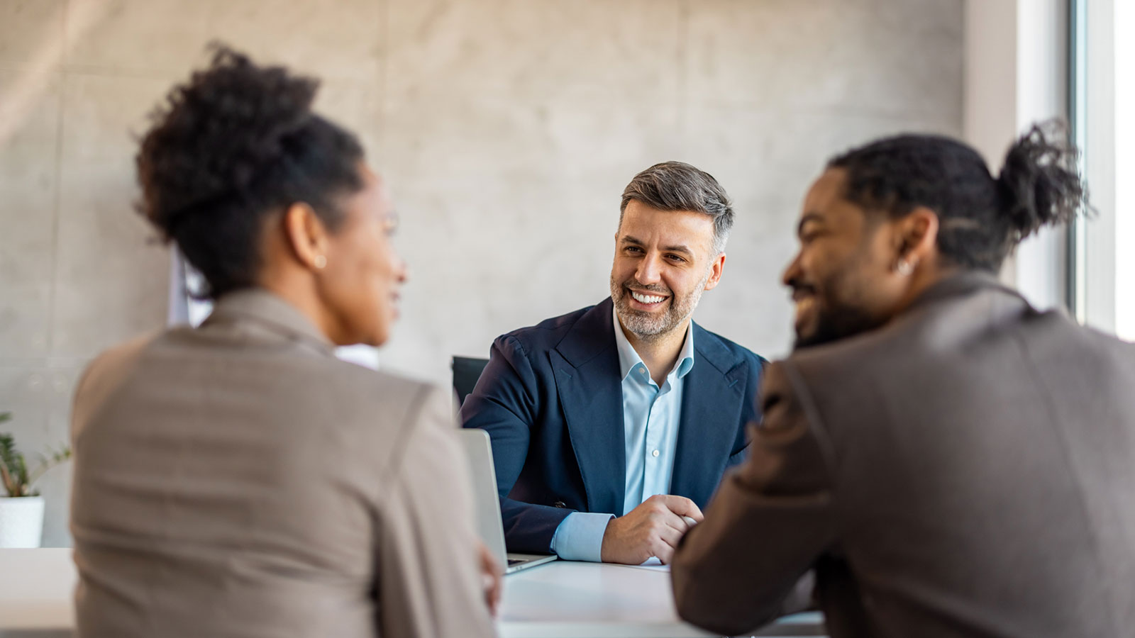 A financial professional meets with two of his team members in his office to talk about strategies to grow his retirement practice.